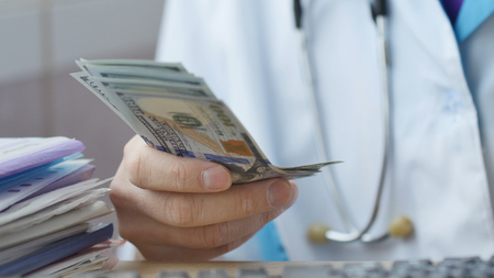 Corrupted medical doctor counting money.の写真素材