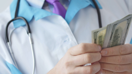 Corrupted medical doctor counting money.