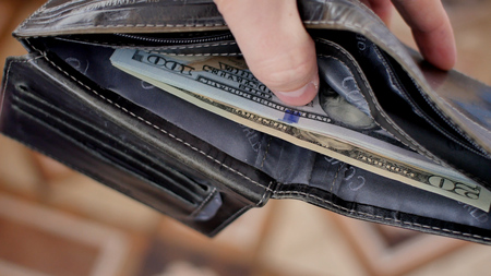 Wallet with US dollars inside. Man counting banknotes inside his wallet. Close-up