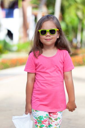 Cute little girl in fashionable sunglasses after shoppingの写真素材