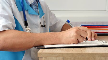 Medical professional doctor writing RX prescription on clipboard.の写真素材