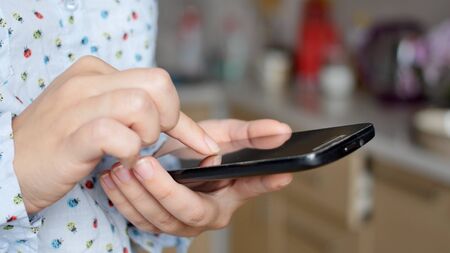 Close-up of young woman hands typing sms