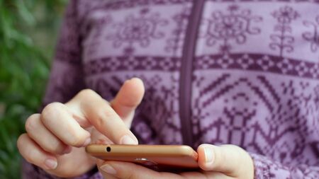 Close-up of young woman hands typing sms