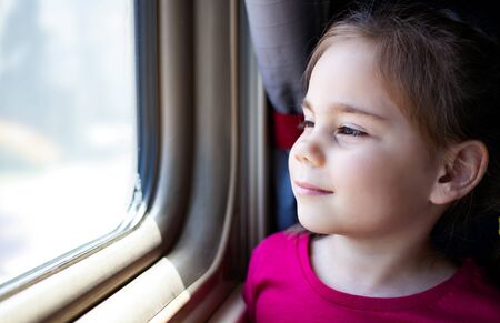 Happy little girl traveling by train.の写真素材