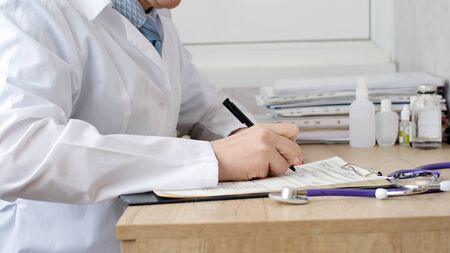Male doctor doing paperwork in the office.の写真素材