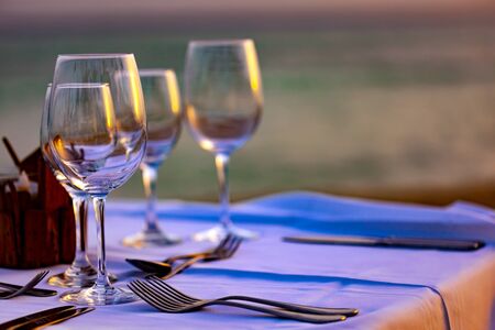 Serving for romantic dinner on a beach at sunset
