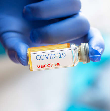 Medical doctor holding tube with nCoV Coronavirus vaccine for COVID-19 virus
