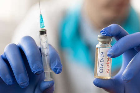 Medical doctor holding tube with nCoV Coronavirus vaccine for COVID-19 virus