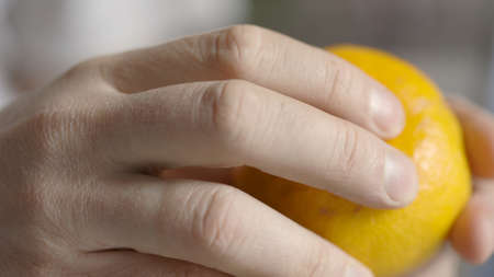 A man cleans tangerine on the table. Hands are peeling fresh tangerine.の写真素材