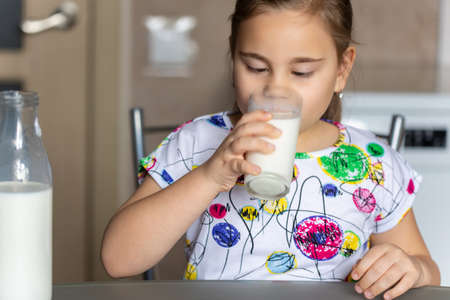 Cute little child girl is drinking milkの写真素材