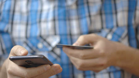 Young man using his phone holding credit card