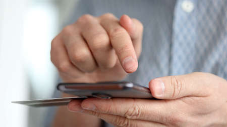 Young man using his phone holding credit cardの写真素材
