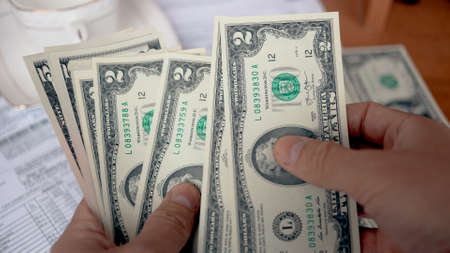 A man counting american dollar bills close-up