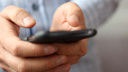 Close up of a man hands playing games on smart phone.