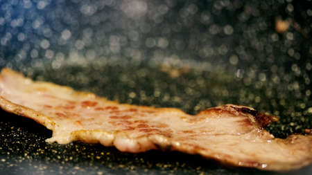 Close up view of bacon slices in frying pan.の写真素材