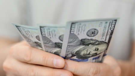 Man counting dollar bills. Close up of male hands count money cash.の写真素材