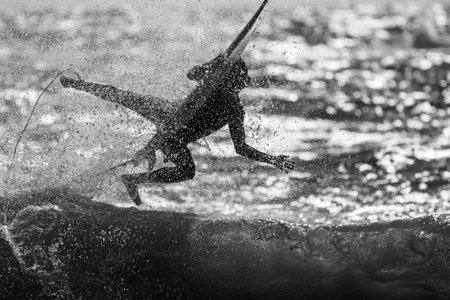 Isolated single surfer surfing the high waves in the sunset- Israelの写真素材