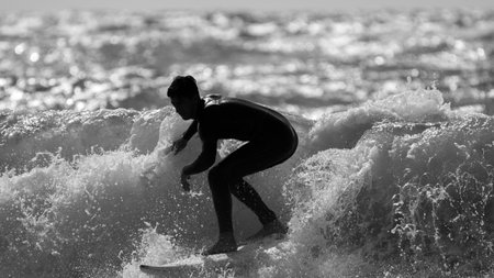 Isolated single surfer surfing the high waves in the sunset- Israelの写真素材