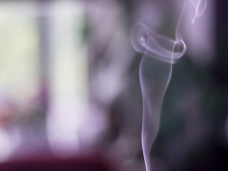 Artistic and relaxing isolated close up incense smoke movement indoors with beautiful bokeh backgroundの写真素材