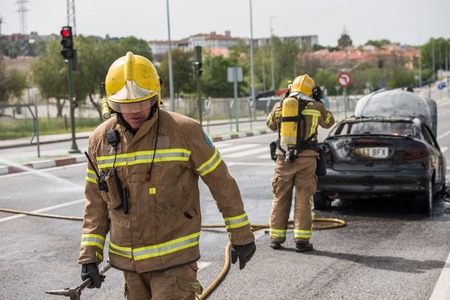 CACERES, EXTREMADURA, SPAIN - APRIL  24, 2018: Firefighters put out a car that has burned on a...