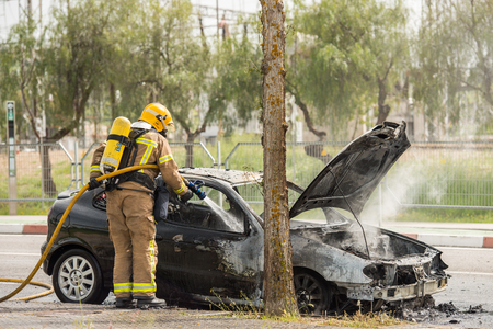 CACERES, EXTREMADURA, SPAIN - APRIL  24, 2018: Firefighters put out a car that has burned on a street in Caceres.のeditorial素材