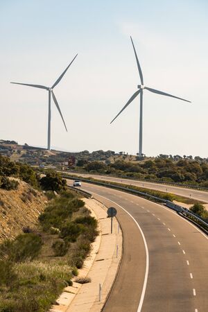 A pair of windmills in the Sierra del Merengue wind farm next to the Ruta de la Plata highway passing through Plasenciaのeditorial素材