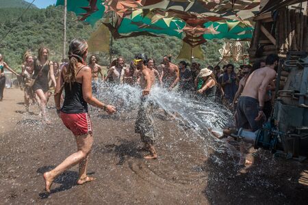 People refresh with water from a cistern on the main stage the Lost Theory psytransce music festivalのeditorial素材