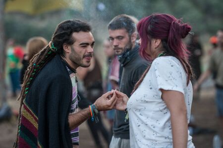 A young man shares a joint with a girl on the main stage of the Lost Theory festival in Riomalo de Abajoのeditorial素材