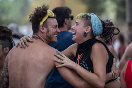 A young man and woman smile as they dance on the main stage of the Lost Theory psytrance festival in Riomalo de Abajoのeditorial素材