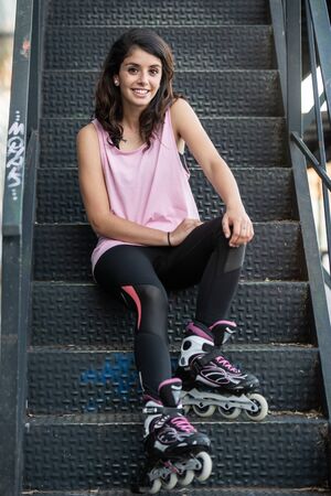 Young brunette woman on rollerskate smiling