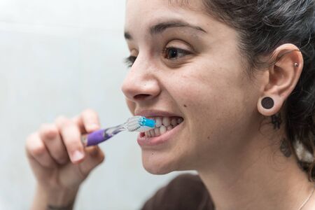 Young woman brushes her white teeth with a toothbrush.の写真素材