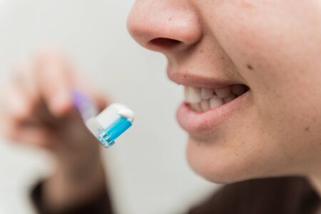 Young woman brushes her white teeth with a toothbrush.の写真素材