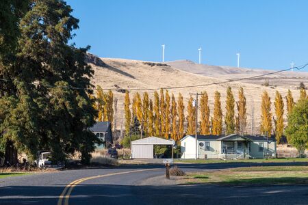 Some houses and cars with a windmill field in the background in Maryhillのeditorial素材