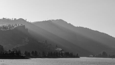 Sunset light streams through the hollows of the hills along the Columbia River near Mosier, Oregonの写真素材