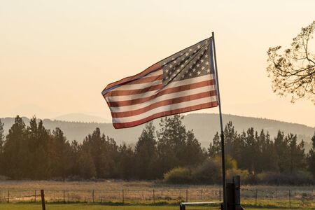 Sunset light passes through a waving U.S. flag near Terrebonneの写真素材