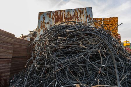 Black tube stack filled with wire rope in a junkyard