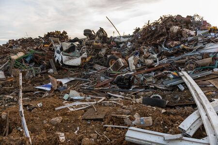 Sunset view of the mountains of scrap metal in a junkyardの写真素材