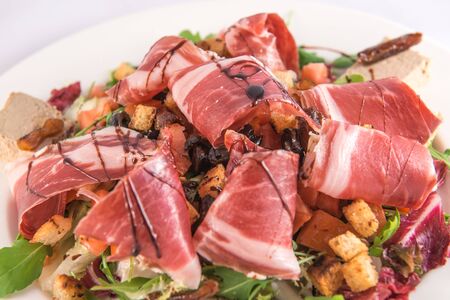 Plate of lambs lettuce salad with croutons, Iberian ham, Iberian mousse and balsamic vinegar from Modenaの写真素材