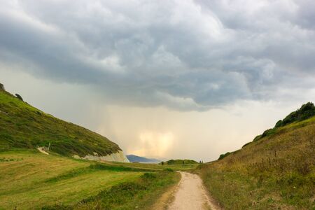Green slopes and footpath along the coast of Zumaiaの写真素材