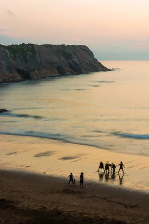 People taking pictures at sunset on the beach in Zumaiaの写真素材