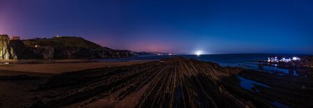 Night view of the flysch with low tide and full moon light in Zumaiaの写真素材