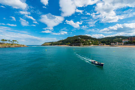 A boat between the mouth of the river Lea and the island of San Nicolas in Lekeitioのeditorial素材