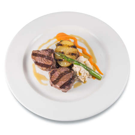 Dish of grilled beef tenderloin medallions with baked potato and asparagusの写真素材