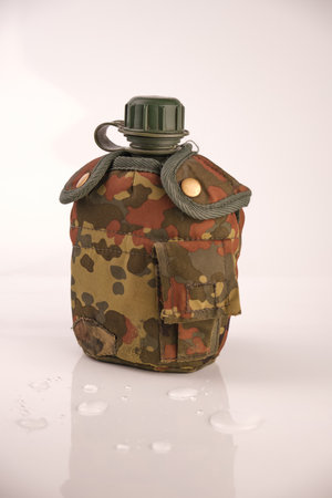 flask plastic army green not new in a camouflage cover on a white background with reflectionの写真素材