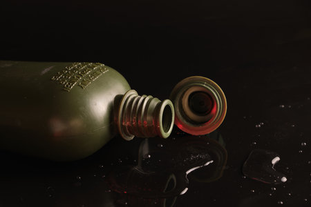 flask plastic army green not new on a black background with reflection and water droplets. opencork. In the supine positionの写真素材