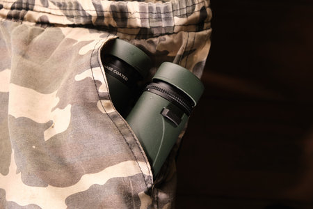 Close up of green binoculars in pocket of camouflage military pantsの写真素材