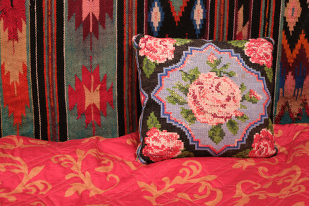 decorative pillow with rose embroidery, handmade, embroidered carpet, bed, wall and blanket red naturalの写真素材