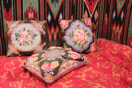 decorative pillows with rose embroidery, handmade, embroidered carpet, bed, wall and blanket red naturalの写真素材