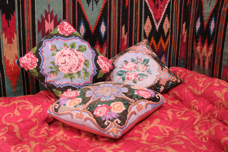 decorative pillows with rose embroidery, handmade, embroidered carpet, bed, wall and blanket red naturalの写真素材
