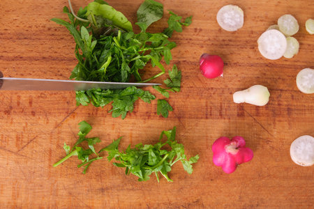 watercress salad, radish, knife and cutting salad, on wooden board isolate, fresh, naturalの写真素材
